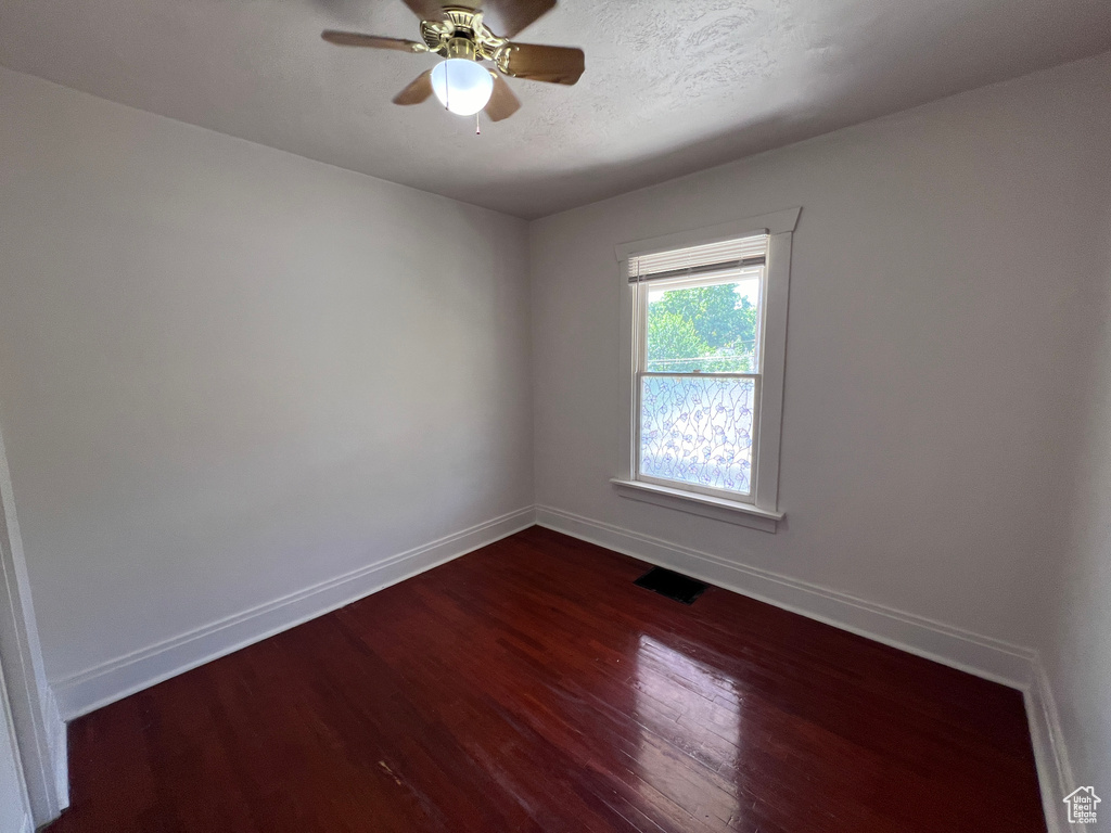 Empty room with hardwood / wood-style flooring and ceiling fan