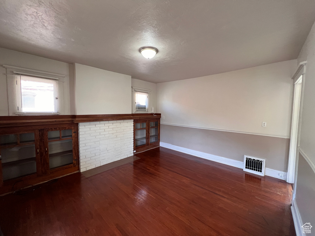 Spare room featuring a textured ceiling and dark hardwood / wood-style flooring