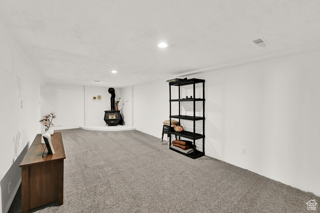 Basement with a wood stove and carpet floors