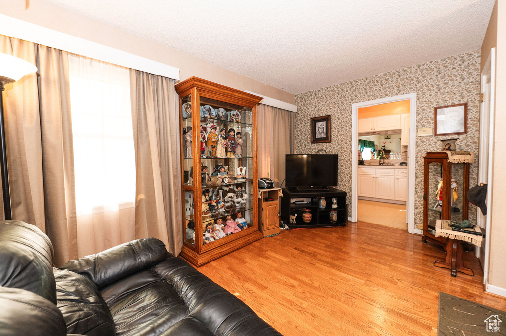 Living room with light wood-type flooring and a textured ceiling