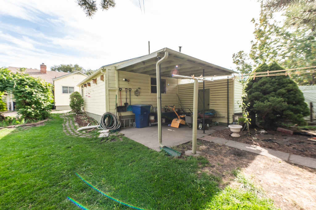 Back of property featuring a lawn and a patio