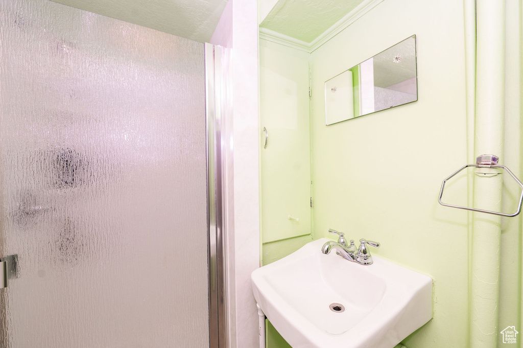 Bathroom featuring ornamental molding and sink