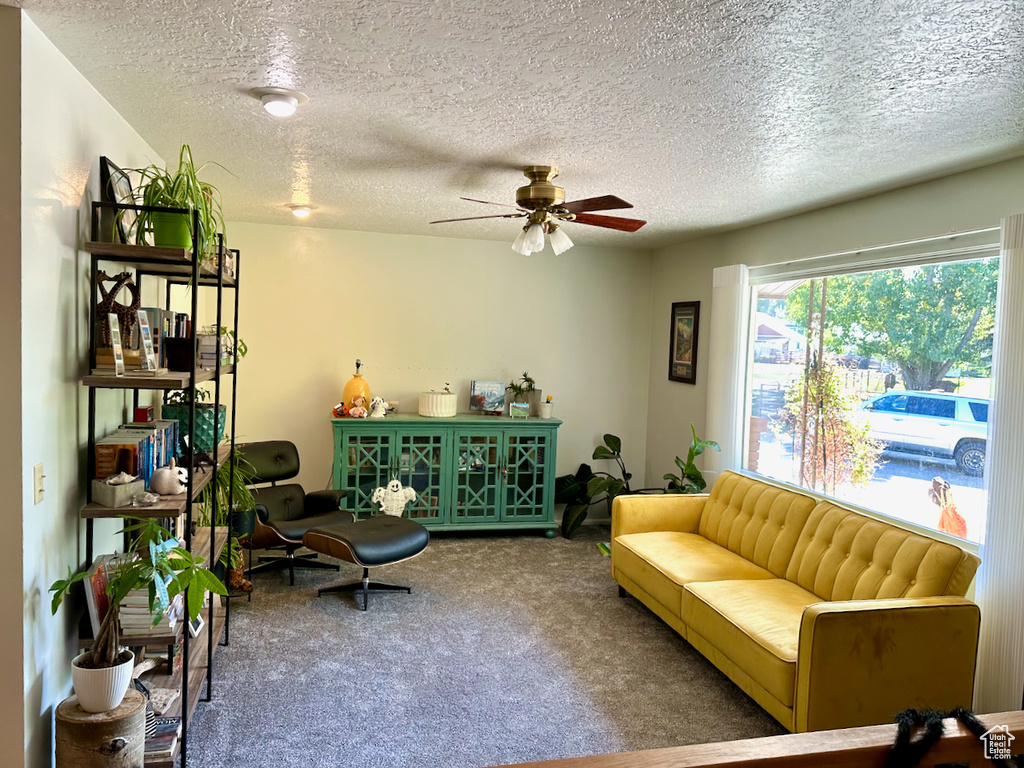 Sitting room featuring carpet floors, a textured ceiling, and ceiling fan