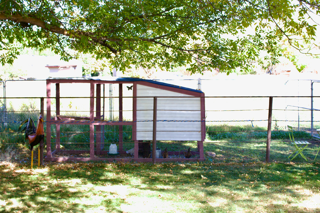 View of outdoor structure featuring a lawn