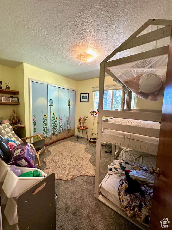 Bedroom featuring carpet and a textured ceiling