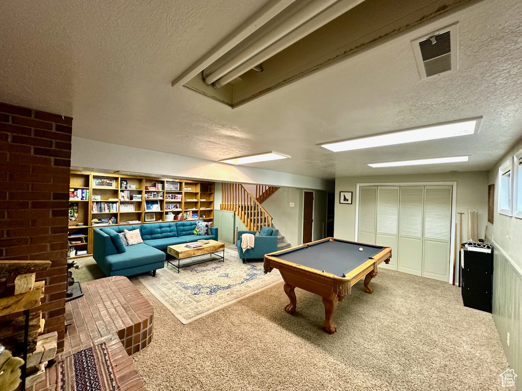 Game room with a textured ceiling, pool table, and carpet