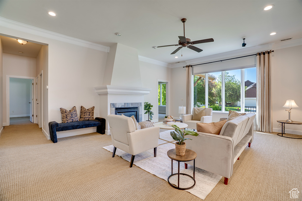 Living room featuring light colored carpet, ornamental molding, recessed lighting, a fireplace, and a ceiling fan