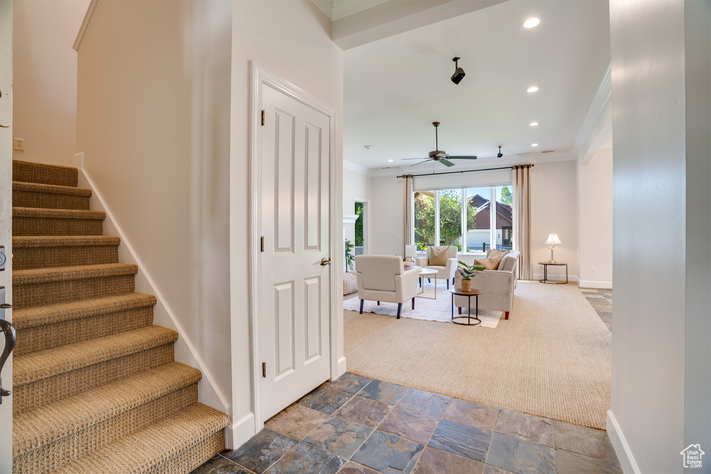 Stairs featuring crown molding, ceiling fan, recessed lighting, baseboards, and stone tile flooring