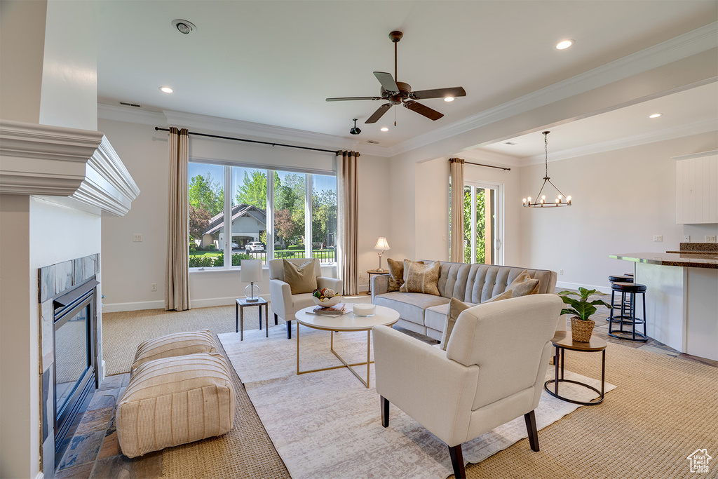 Living area featuring a fireplace, ornamental molding, ceiling fan, baseboards, and recessed lighting