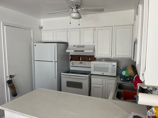 Kitchen featuring ceiling fan, kitchen peninsula, white appliances, and white cabinetry