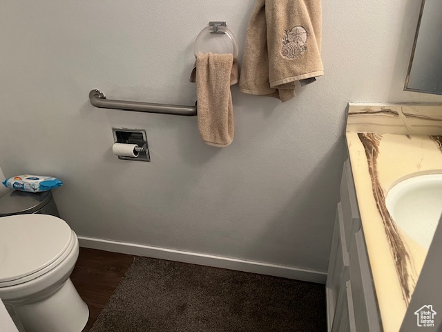 Bathroom with vanity, toilet, and hardwood / wood-style flooring