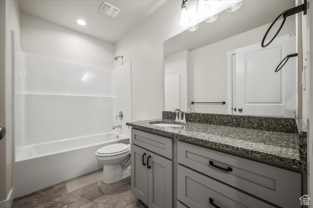 Full bathroom featuring bathing tub / shower combination, vanity, and toilet
