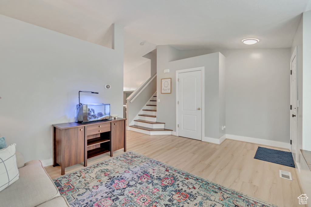 Foyer featuring vaulted ceiling and light hardwood / wood-style floors