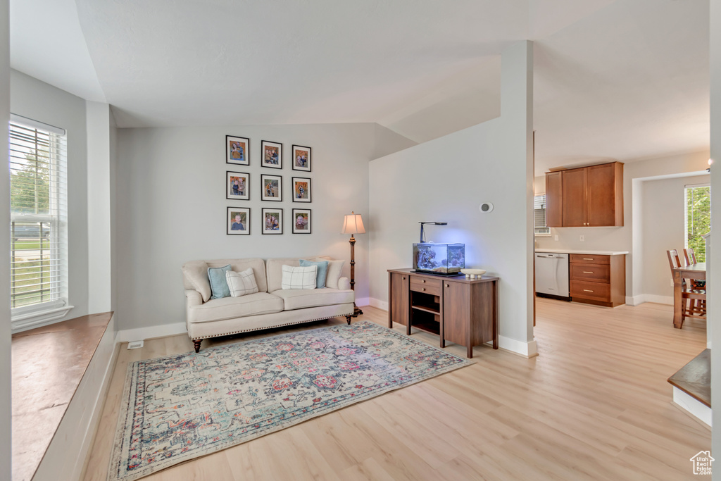 Living room with vaulted ceiling and light hardwood / wood-style flooring