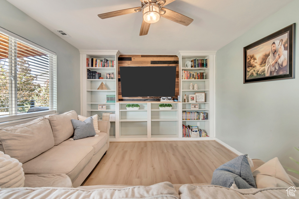 Living room with ceiling fan and light wood-type flooring