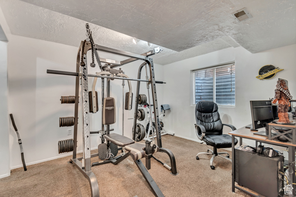 Exercise area with carpet and a textured ceiling