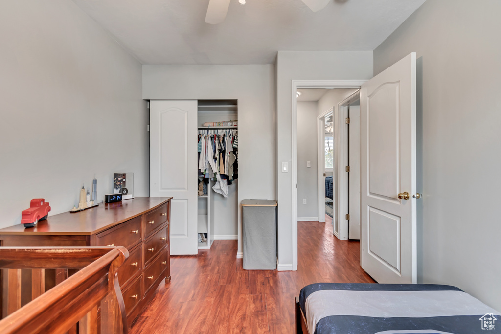 Bedroom with a closet, dark hardwood / wood-style flooring, and ceiling fan