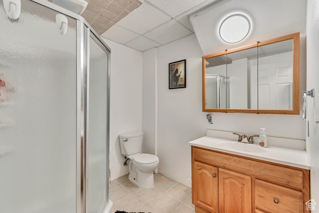 Bathroom featuring walk in shower, a drop ceiling, vanity, and toilet