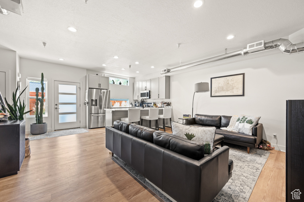 Living room featuring light wood-type flooring and a textured ceiling