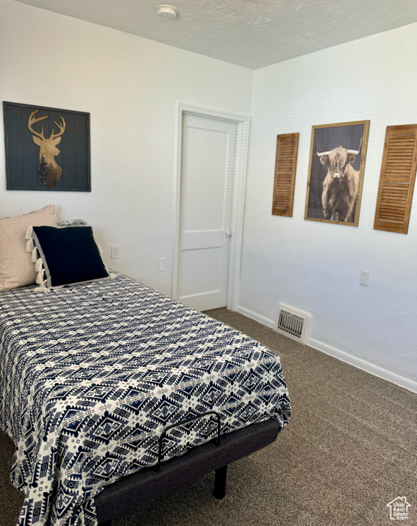 Bedroom with carpet floors and a textured ceiling