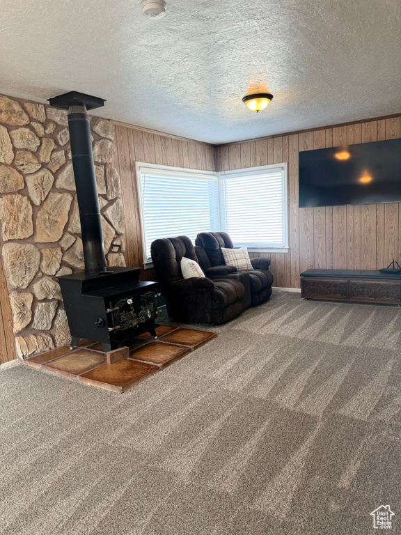 Unfurnished living room with carpet, wooden walls, and a textured ceiling