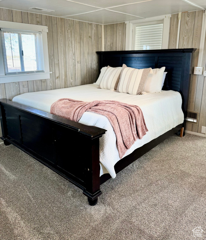 Carpeted bedroom with wood walls