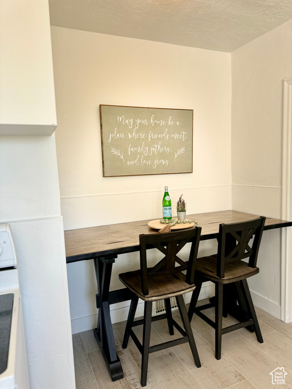 Dining area with wood-type flooring and a textured ceiling