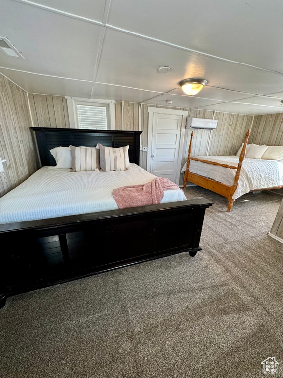 Carpeted bedroom featuring wood walls