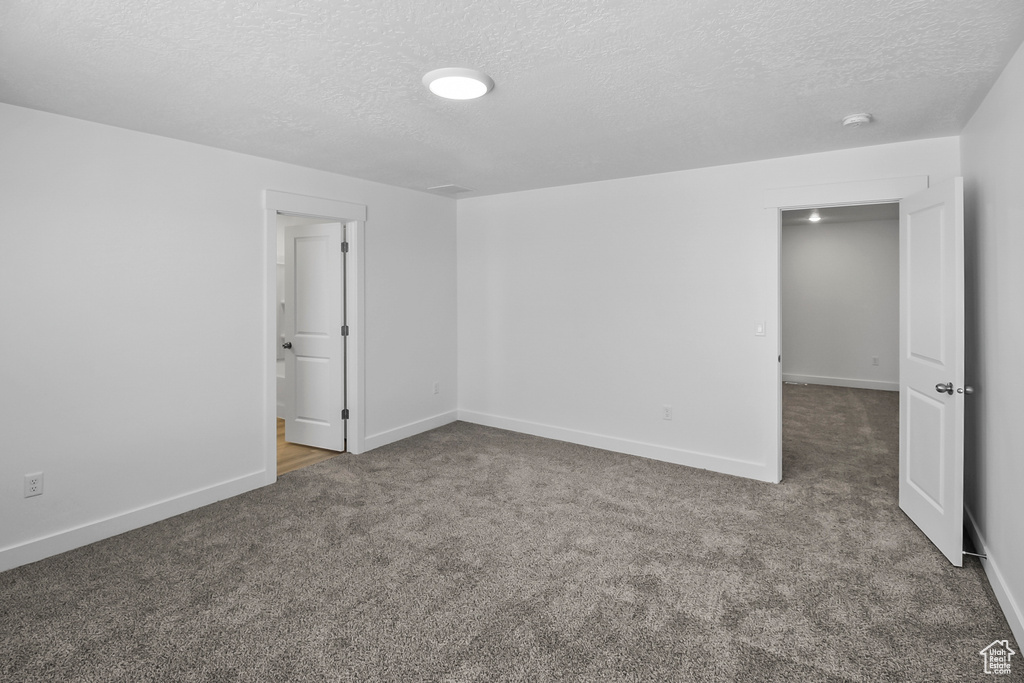 Unfurnished room featuring carpet floors and a textured ceiling