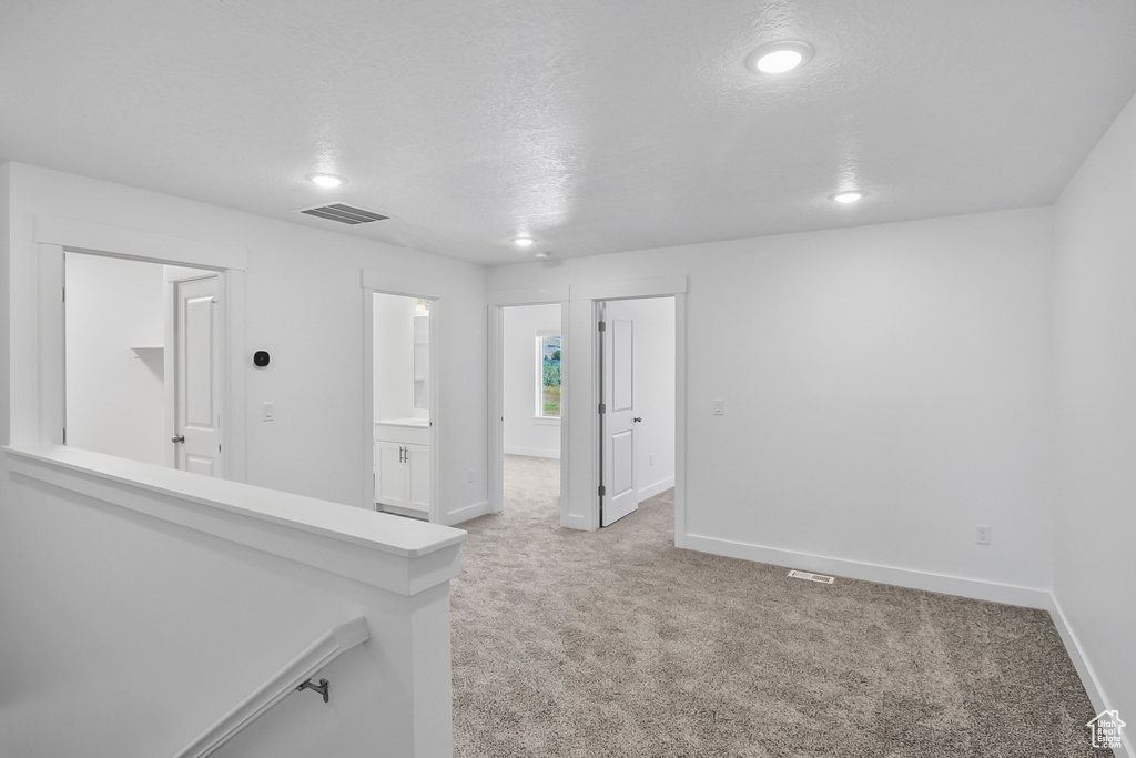 Carpeted empty room featuring a textured ceiling