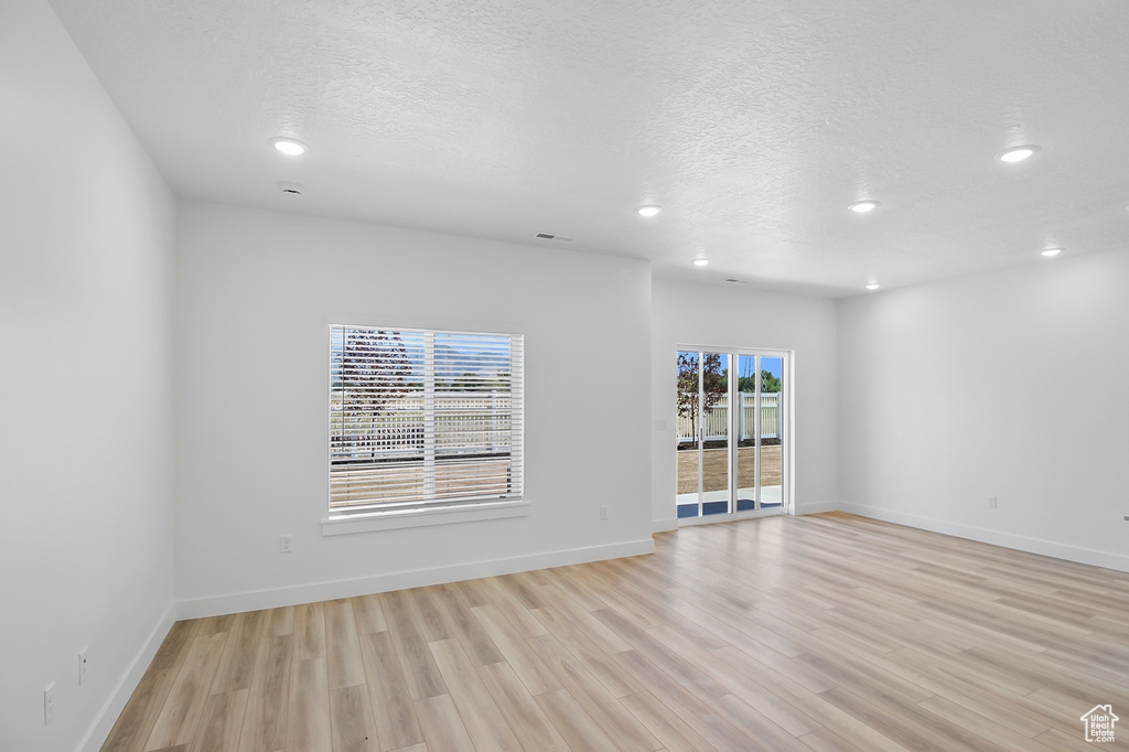 Empty room featuring light hardwood / wood-style floors and a textured ceiling