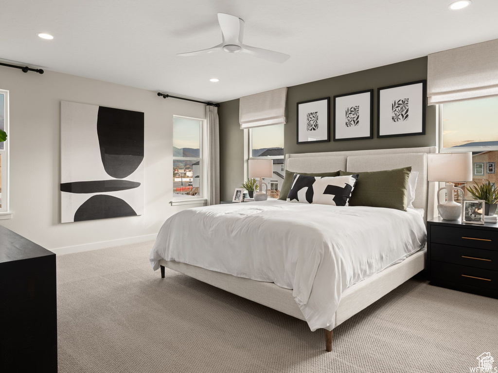 Bedroom with ceiling fan and light colored carpet