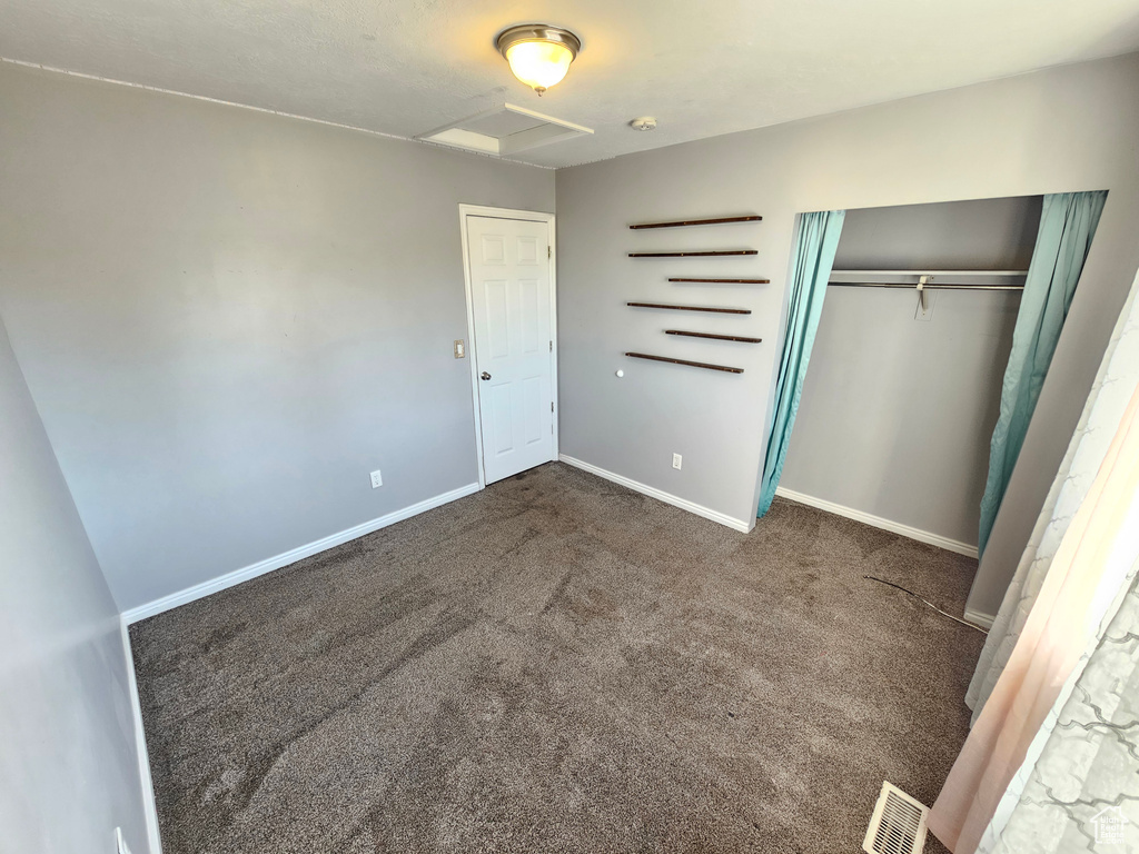 Unfurnished bedroom featuring a closet and carpet