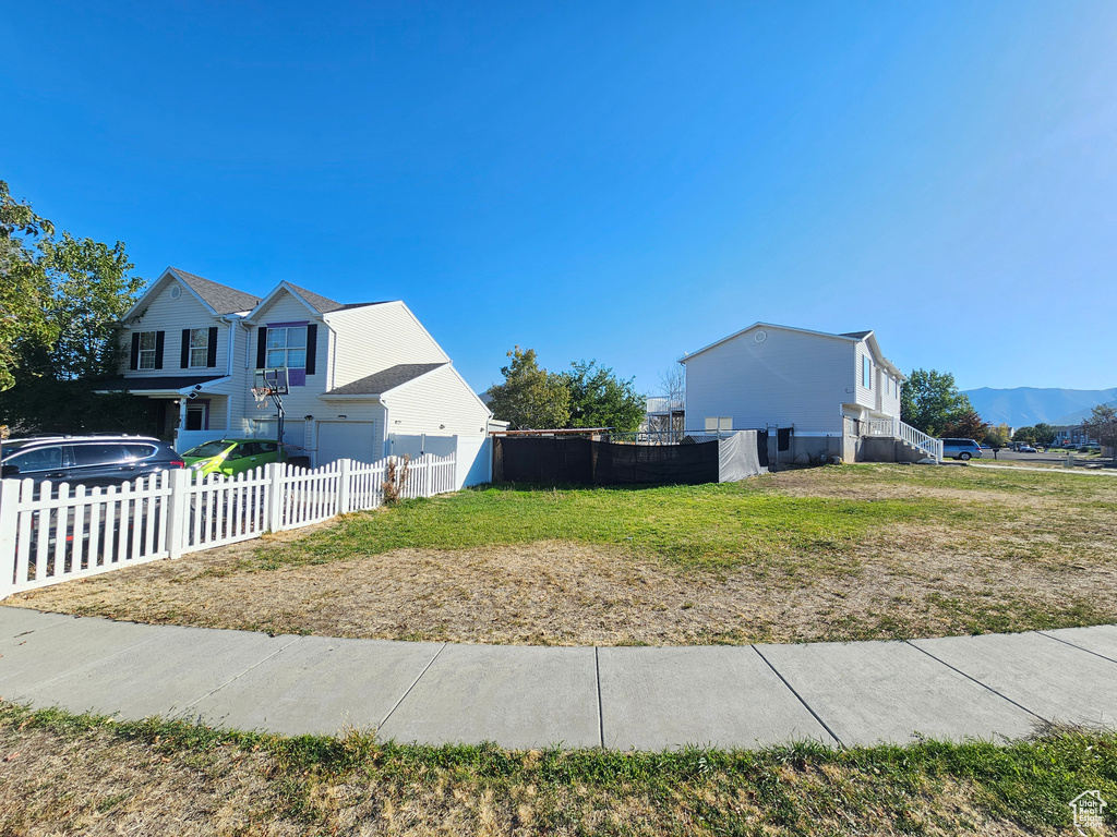 View of side of property with a yard and a mountain view