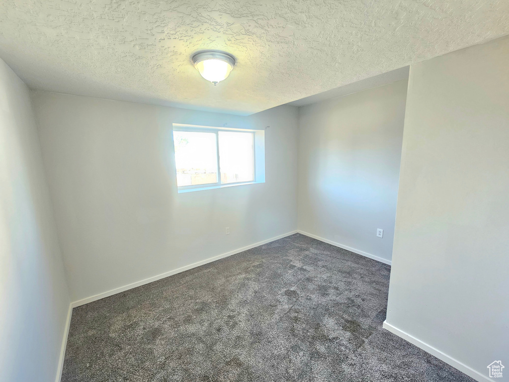 Carpeted spare room featuring a textured ceiling