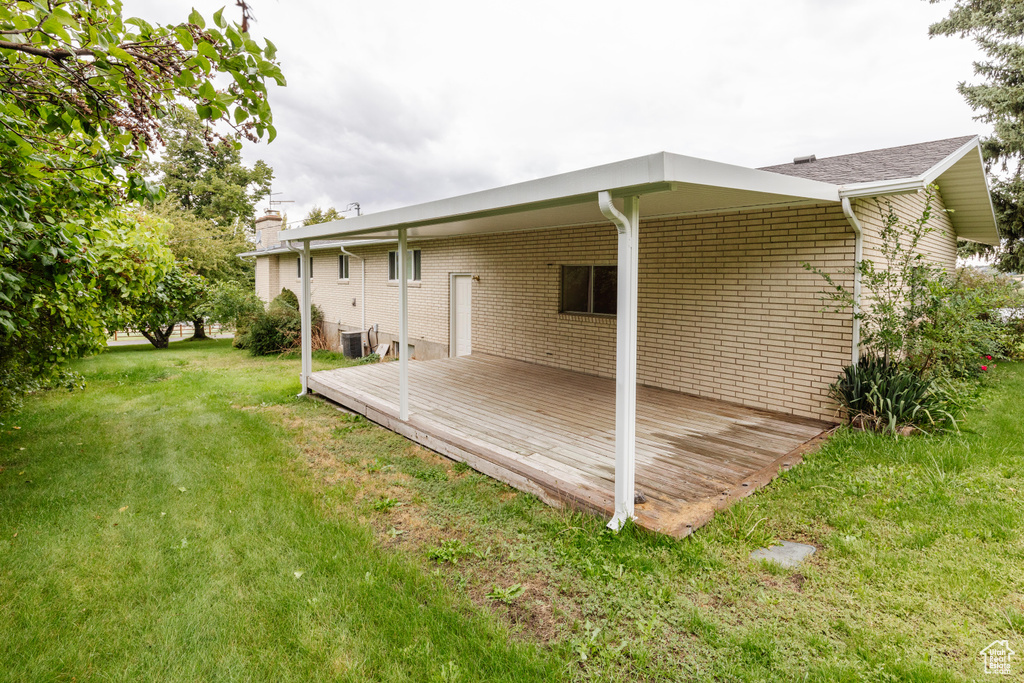 Exterior space featuring cooling unit and a yard