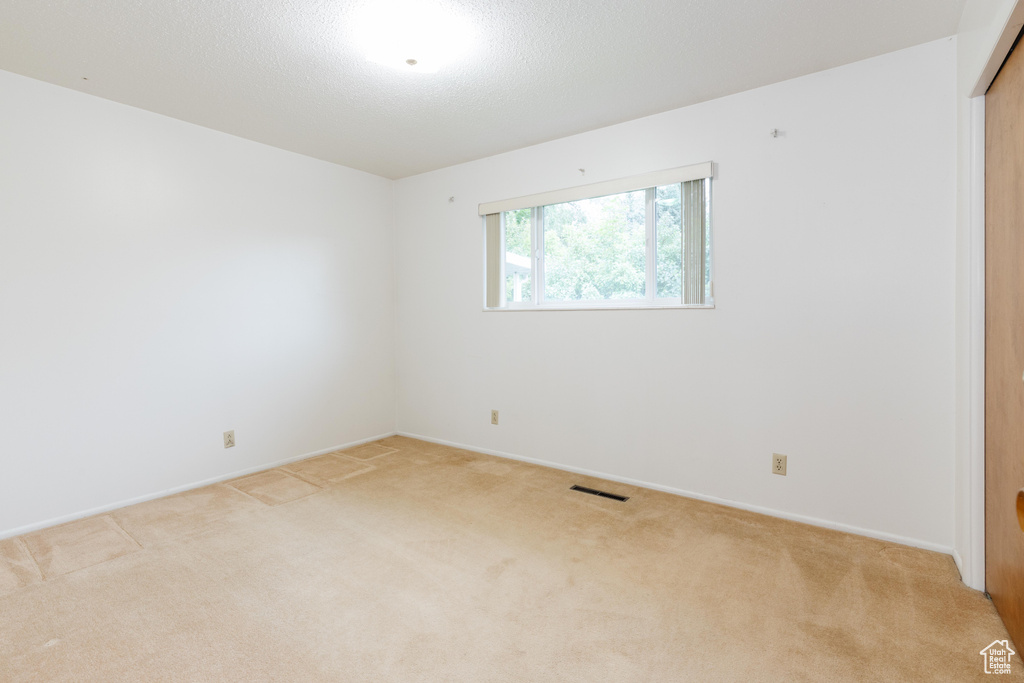 Spare room featuring light colored carpet