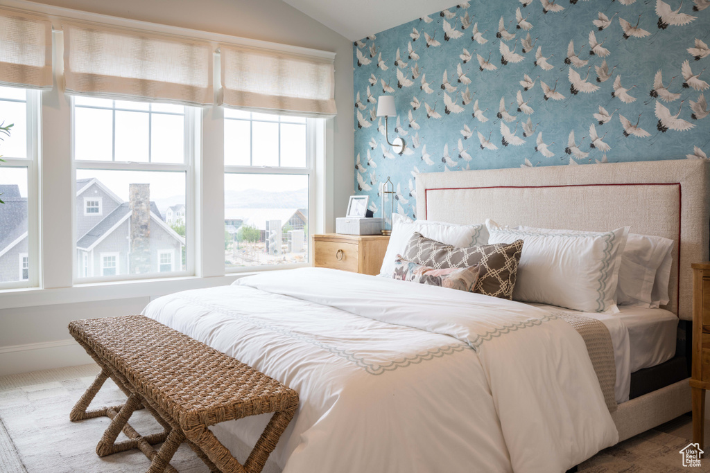 Bedroom with lofted ceiling and multiple windows