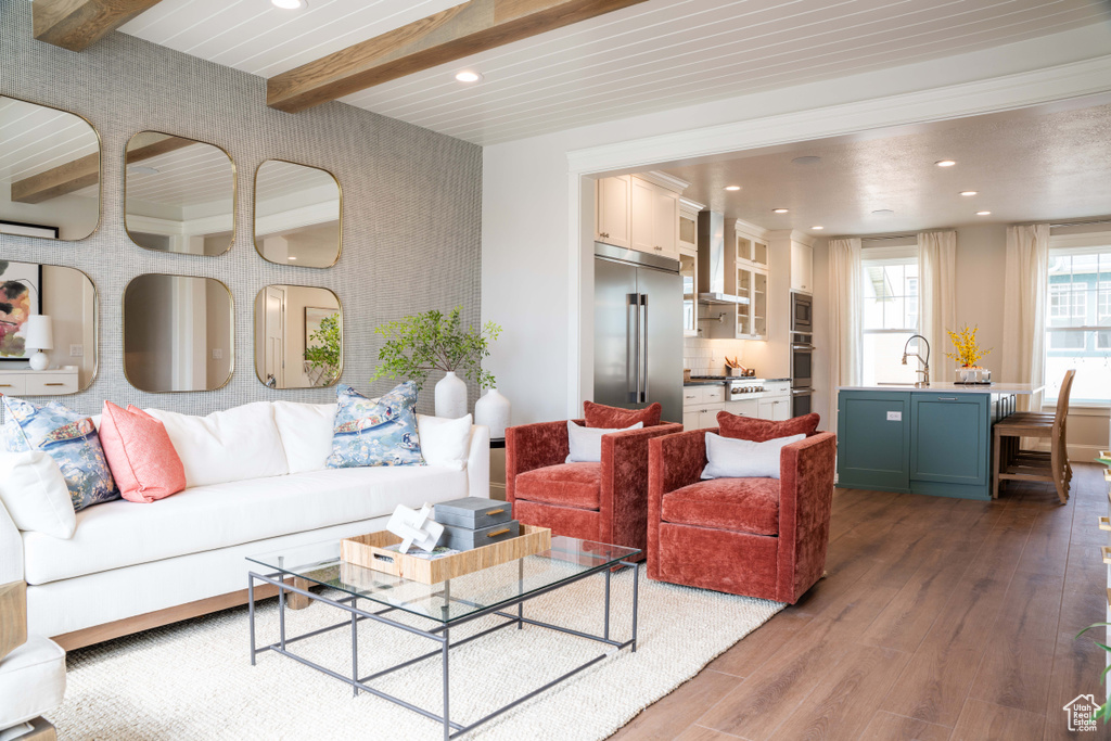 Living room featuring dark hardwood / wood-style floors, beam ceiling, and sink