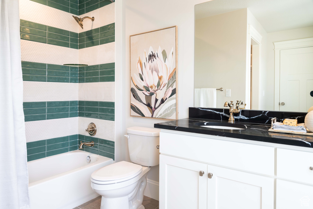 Full bathroom with shower / bath combination with curtain, vanity, and toilet