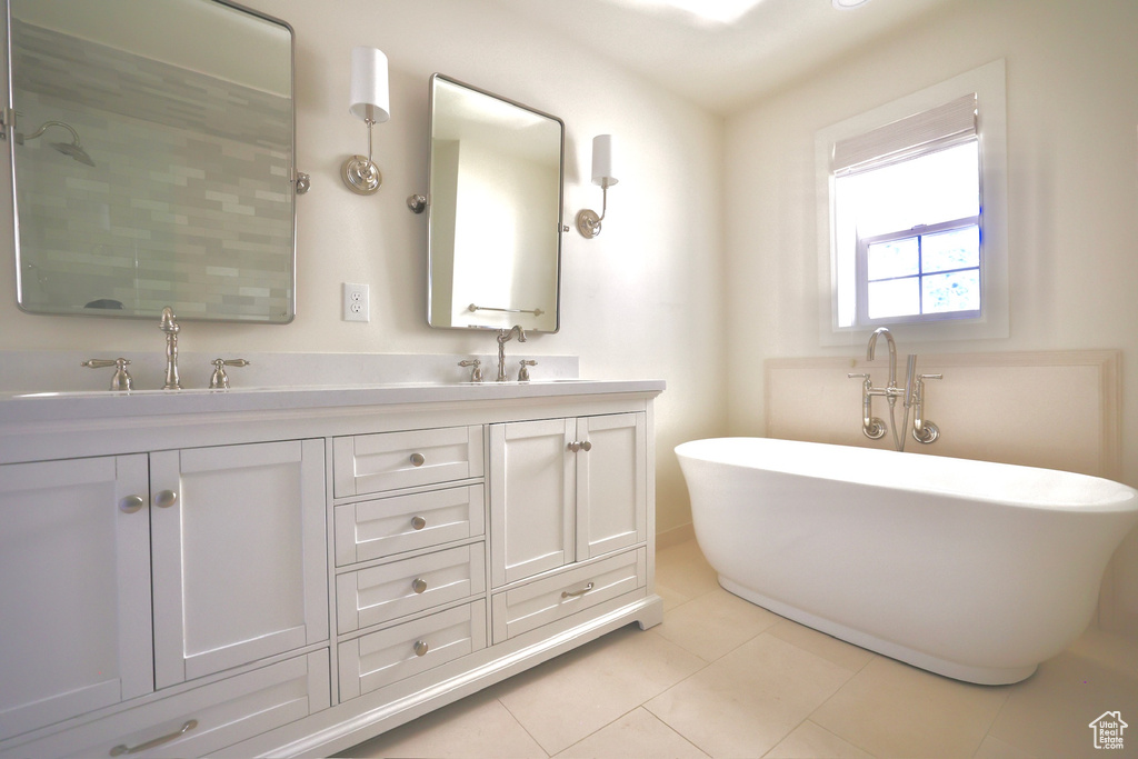 Bathroom featuring tile patterned flooring, a tub, and vanity