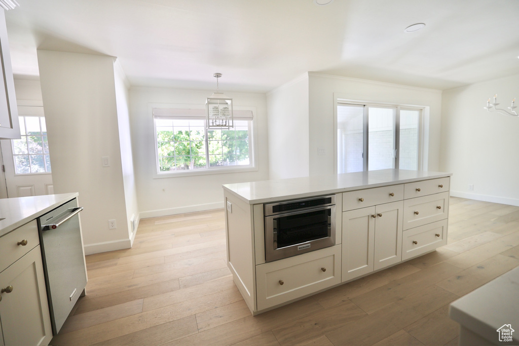 Kitchen featuring hanging light fixtures, appliances with stainless steel finishes, plenty of natural light, and light hardwood / wood-style floors