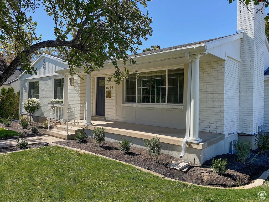 Ranch-style house featuring a front lawn and covered porch