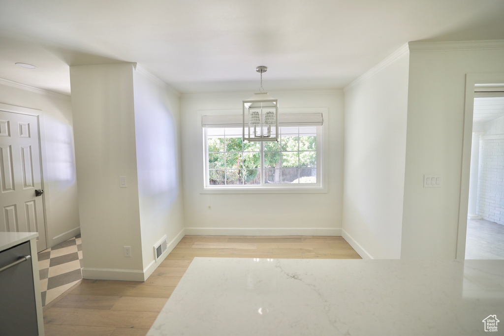 Dining area featuring ornamental molding and light wood-type flooring