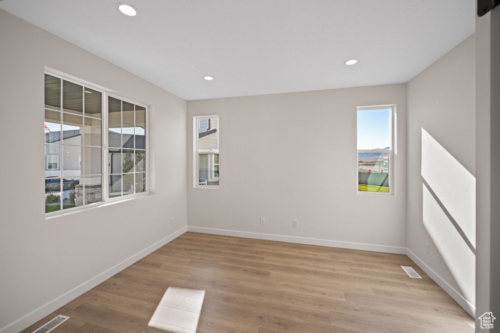 Unfurnished room featuring plenty of natural light and light hardwood / wood-style floors