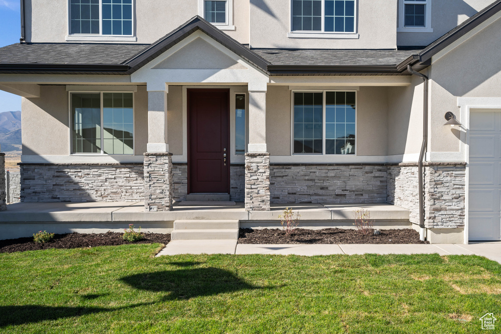 View of exterior entry with a lawn