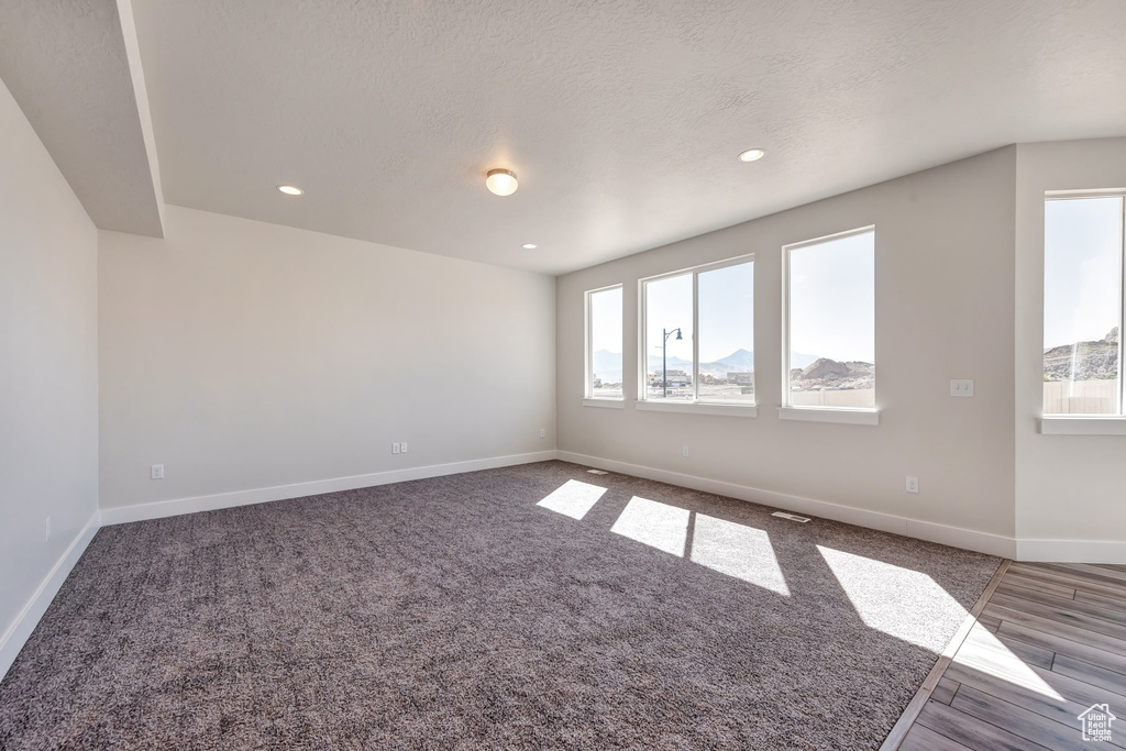 Unfurnished room featuring dark hardwood / wood-style floors and a textured ceiling