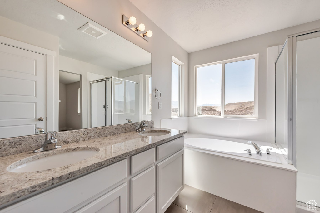 Bathroom featuring tile patterned flooring, plus walk in shower, and vanity