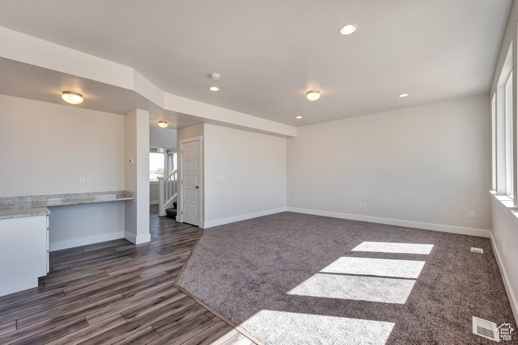 Living room featuring dark hardwood / wood-style floors and a healthy amount of sunlight