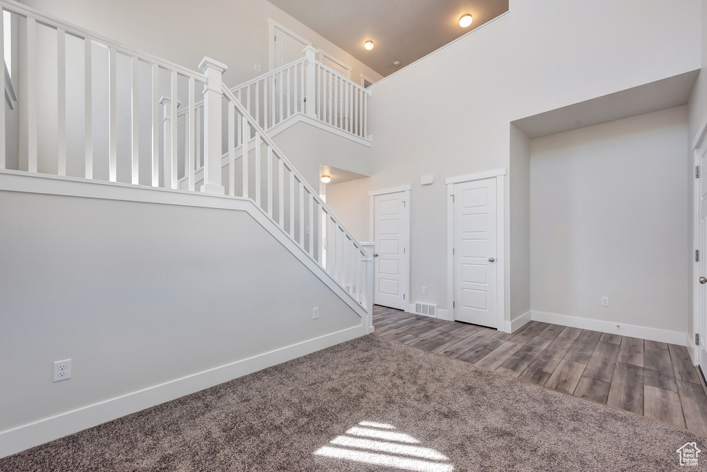 Interior space featuring a high ceiling and dark hardwood / wood-style flooring